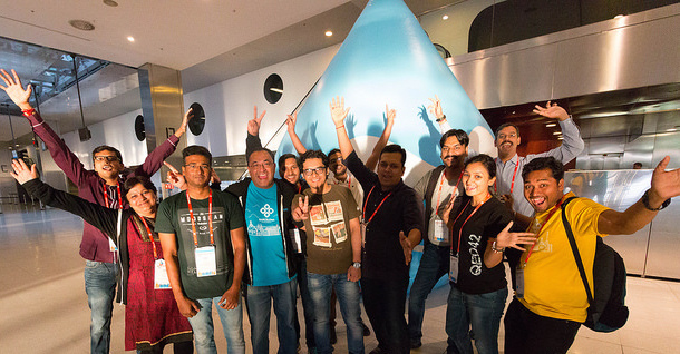 The DrupalCon Asia team cheering with Druplicon