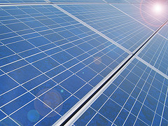Solar panels reflecting a bright sun.